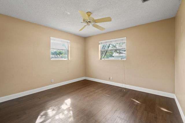 unfurnished room with dark wood-style floors, ceiling fan, a textured ceiling, and baseboards