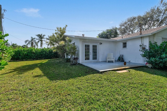 back of house featuring a yard, french doors, a patio, and stucco siding