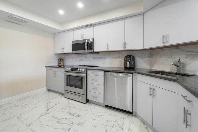 kitchen with sink, white cabinetry, stainless steel appliances, and tasteful backsplash