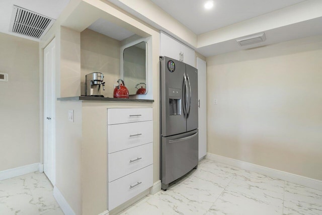 kitchen with stainless steel fridge with ice dispenser and white cabinets