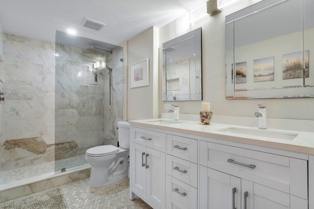 bathroom featuring tile patterned floors, vanity, toilet, and tiled shower