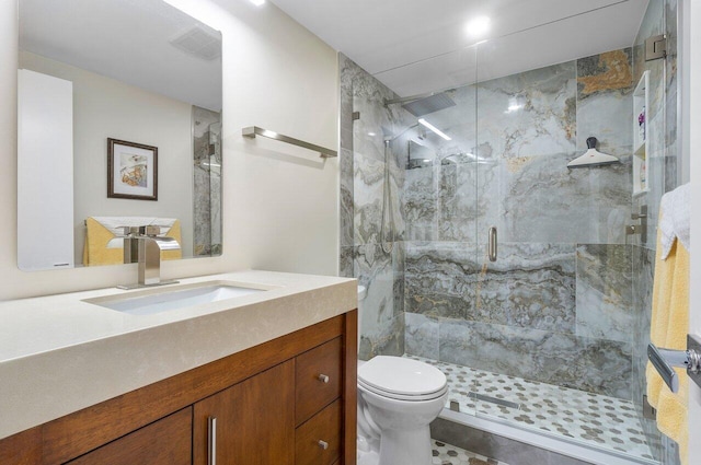 bathroom with an enclosed shower, vanity, and toilet