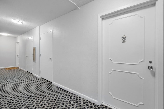 hallway featuring a textured ceiling and carpet floors