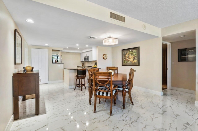 dining area featuring a textured ceiling