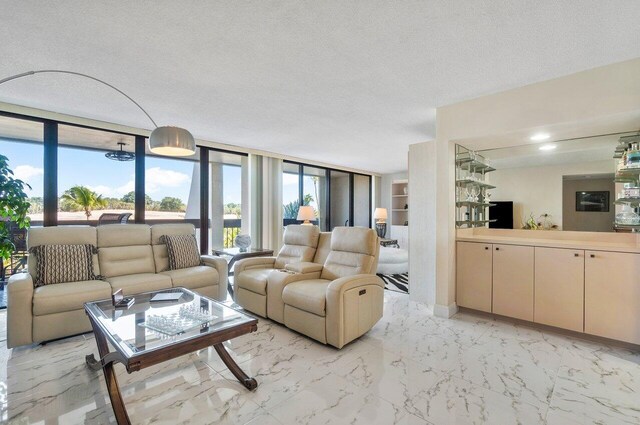 living room featuring expansive windows and a textured ceiling