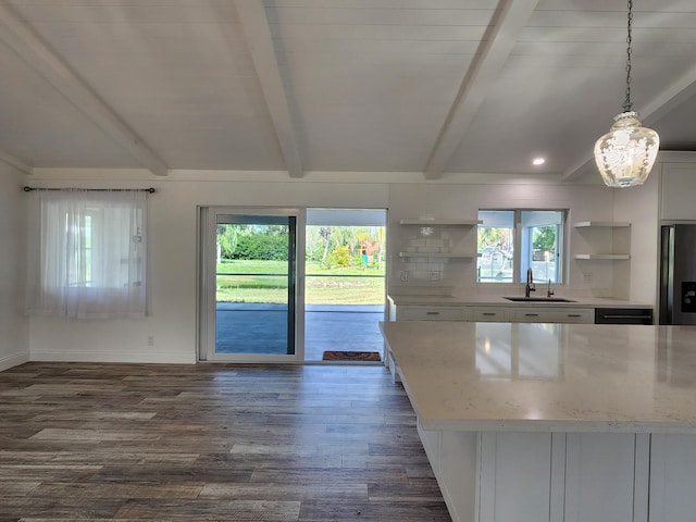 kitchen featuring decorative light fixtures, white cabinetry, sink, and a wealth of natural light