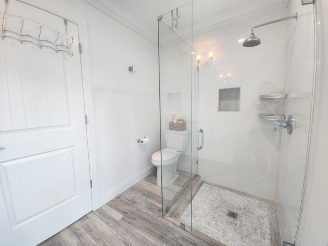 bathroom featuring walk in shower, crown molding, hardwood / wood-style floors, and toilet