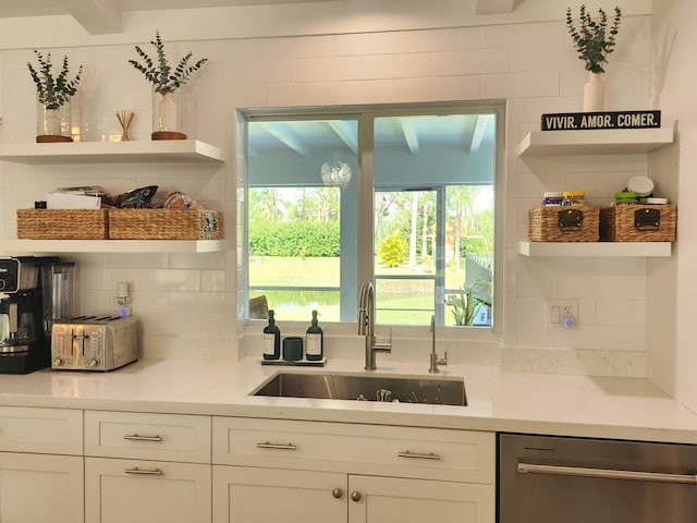 kitchen with dishwasher, tasteful backsplash, white cabinetry, and sink