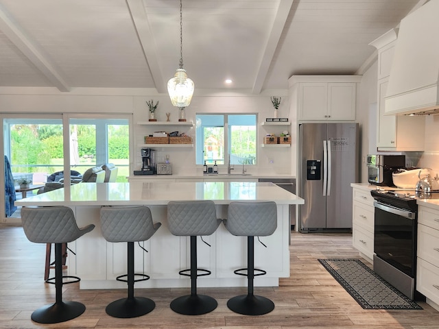 kitchen with white cabinets, beam ceiling, stainless steel appliances, and plenty of natural light