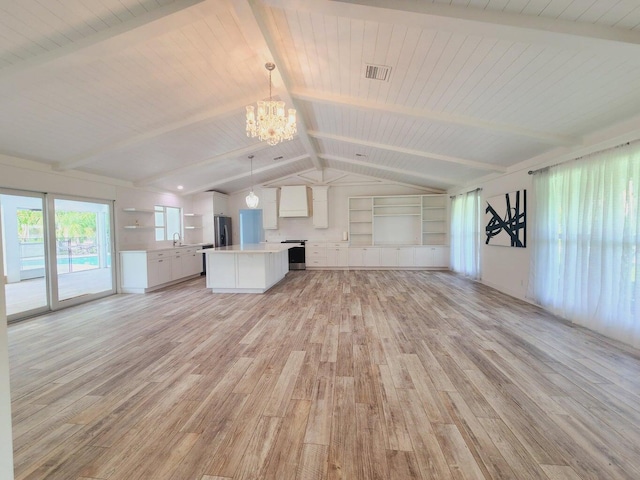 unfurnished living room featuring vaulted ceiling with beams, a chandelier, sink, and light hardwood / wood-style flooring