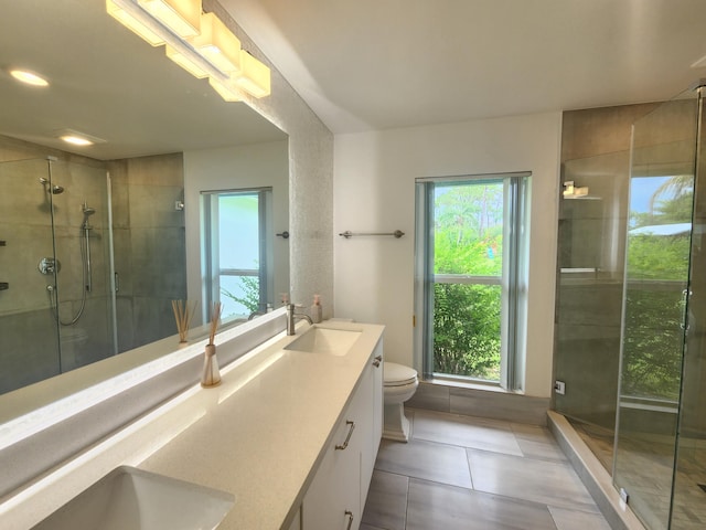 bathroom featuring tile patterned flooring, vanity, toilet, and a shower with door