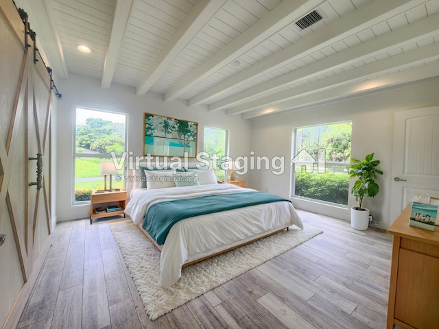 bedroom featuring multiple windows, light hardwood / wood-style flooring, and beamed ceiling