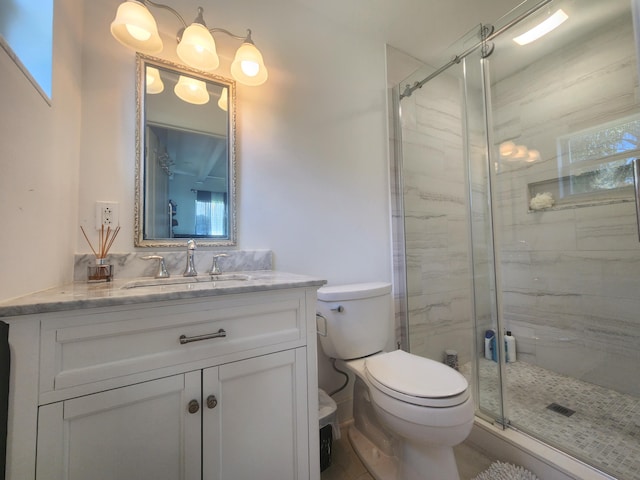 bathroom with vanity, toilet, and a shower with shower door