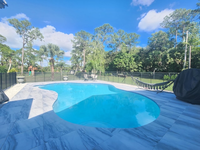 view of swimming pool featuring grilling area, a yard, and a patio