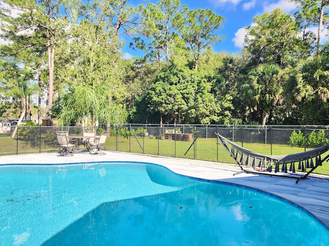 view of swimming pool with a yard