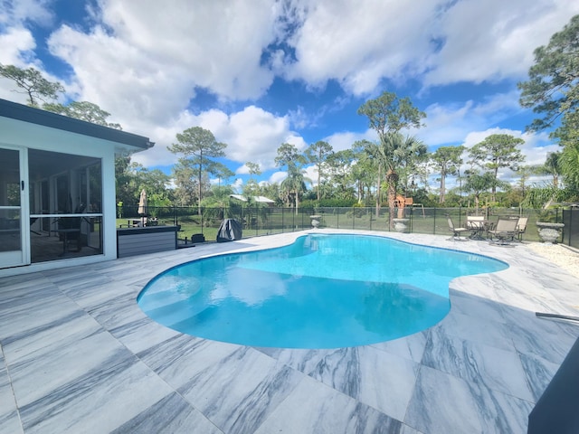 view of swimming pool featuring a patio area and a sunroom