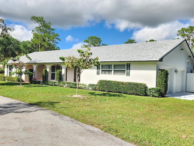 single story home featuring a garage and a front lawn