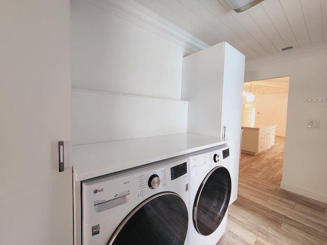 laundry room featuring washer and dryer, light hardwood / wood-style flooring, and crown molding