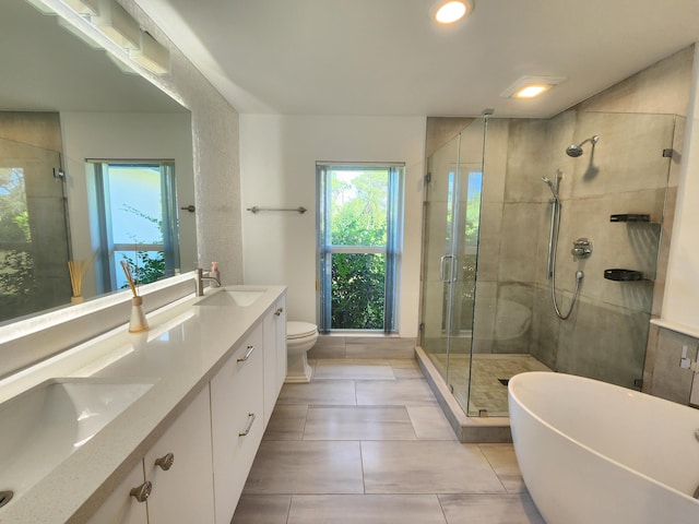 full bathroom with tile patterned floors, separate shower and tub, vanity, and toilet