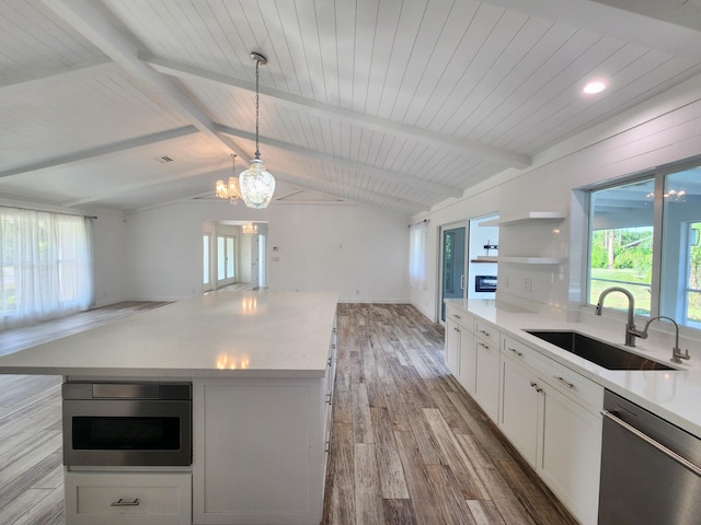 kitchen with lofted ceiling with beams, sink, hanging light fixtures, light hardwood / wood-style floors, and stainless steel appliances