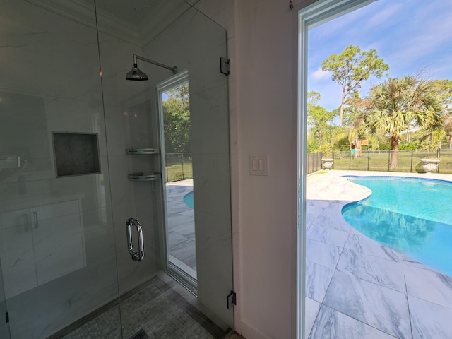 bathroom with a shower with door and crown molding