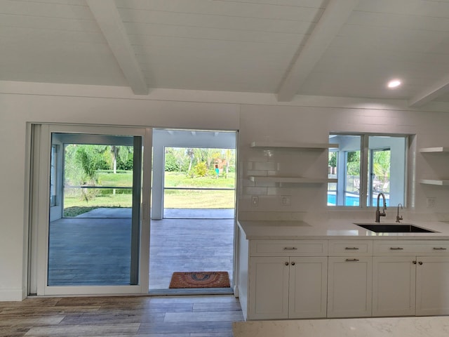 kitchen featuring light hardwood / wood-style floors, white cabinetry, a wealth of natural light, and sink