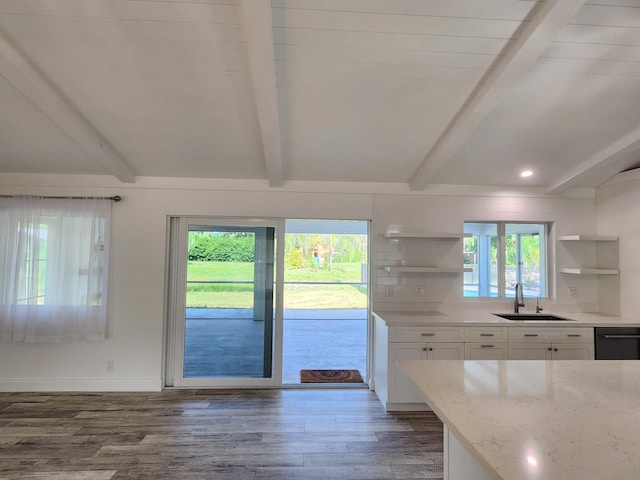 kitchen with light stone counters, dark wood-type flooring, sink, white cabinetry, and plenty of natural light