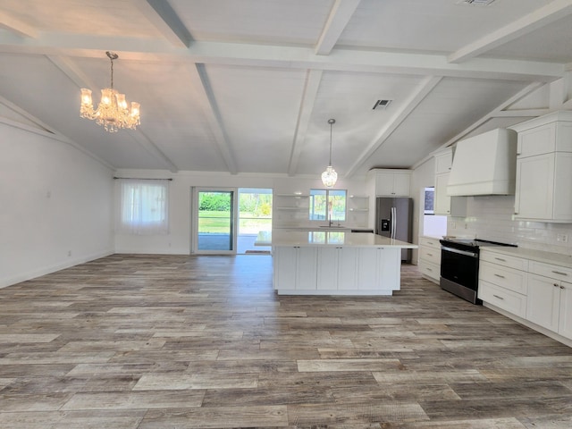 kitchen featuring premium range hood, white cabinets, lofted ceiling with beams, hanging light fixtures, and appliances with stainless steel finishes