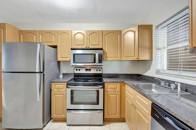 kitchen featuring light brown cabinets, light tile patterned floors, sink, and appliances with stainless steel finishes