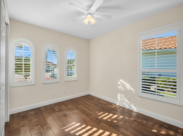 empty room with dark hardwood / wood-style floors and ceiling fan