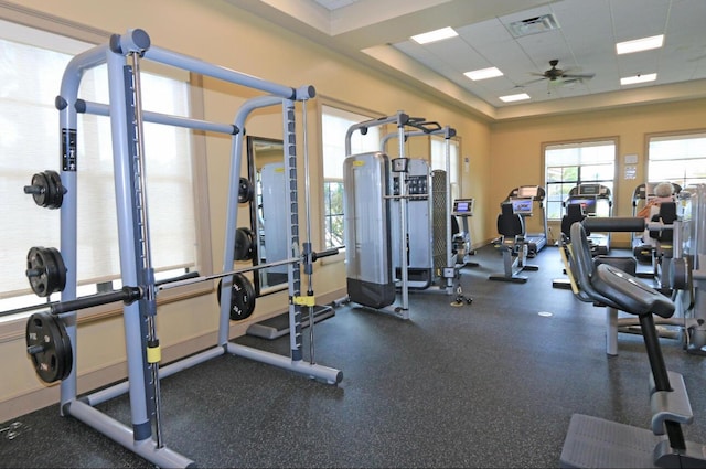 exercise room with a paneled ceiling and ceiling fan