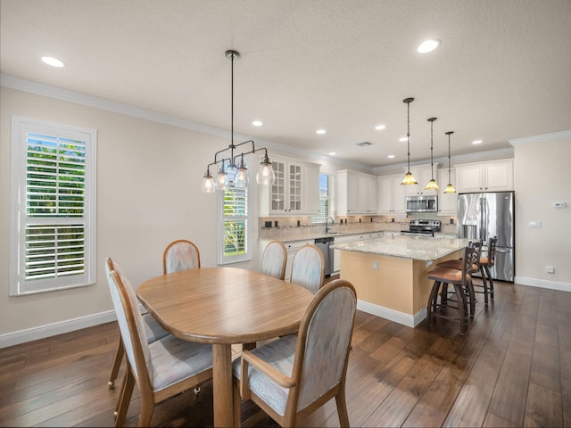 dining room featuring ornamental molding, a healthy amount of sunlight, and dark hardwood / wood-style flooring