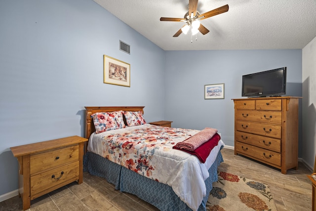 bedroom featuring ceiling fan, light hardwood / wood-style floors, and a textured ceiling