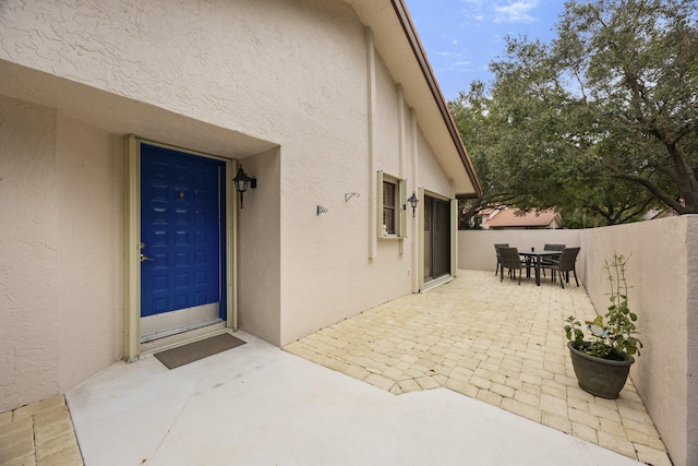 view of exterior entry with a patio