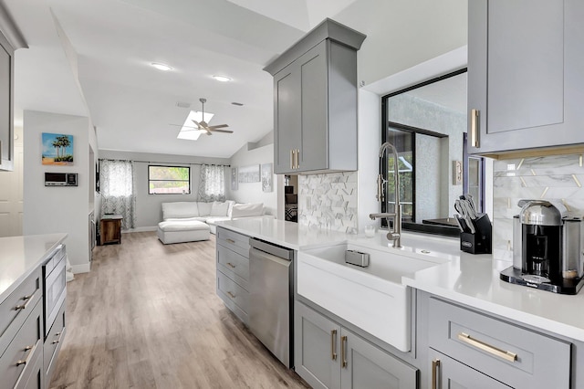 kitchen with tasteful backsplash, light hardwood / wood-style floors, vaulted ceiling, dishwasher, and gray cabinets