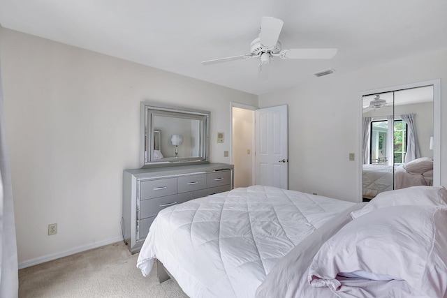 bedroom featuring a closet, light colored carpet, and ceiling fan