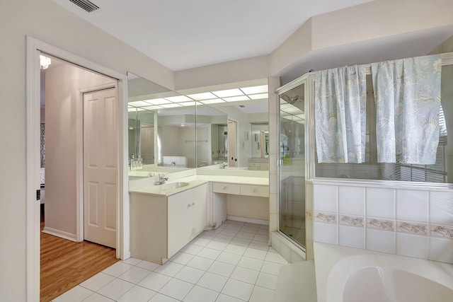 bathroom with independent shower and bath, vanity, and wood-type flooring