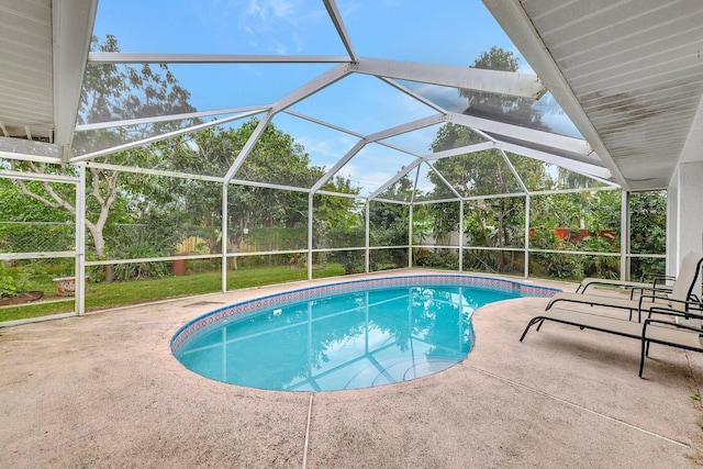 view of pool featuring glass enclosure and a patio