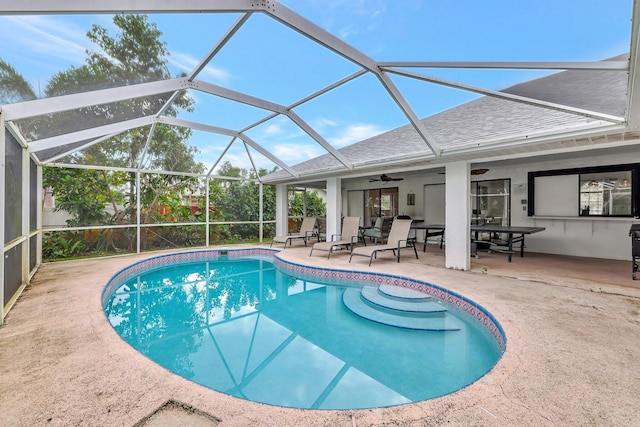 view of swimming pool with a patio, ceiling fan, and a lanai