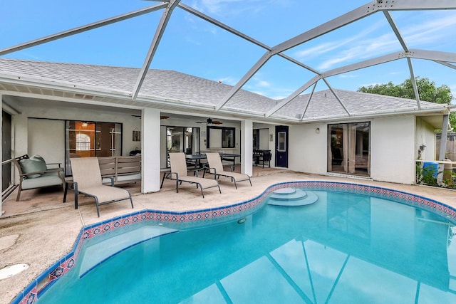 view of swimming pool with ceiling fan, a patio area, an outdoor living space, and glass enclosure