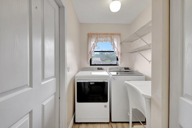 laundry room featuring washer and dryer and light hardwood / wood-style floors