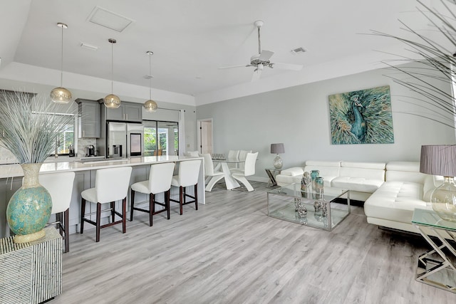 living room with ceiling fan and light hardwood / wood-style flooring