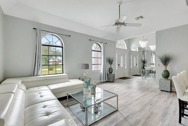 living room featuring ceiling fan with notable chandelier and hardwood / wood-style flooring