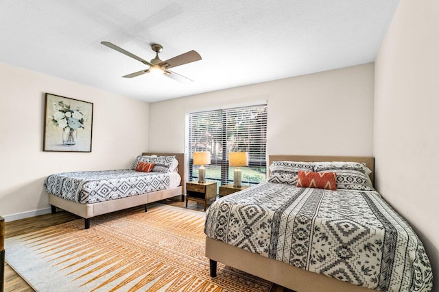 bedroom featuring ceiling fan, wood-type flooring, and a textured ceiling