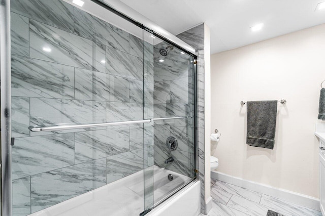 bathroom featuring toilet and bath / shower combo with glass door