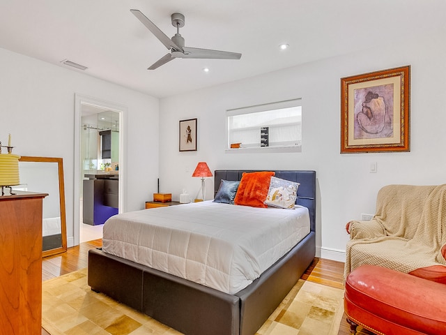 bedroom with ceiling fan, ensuite bathroom, and light wood-type flooring