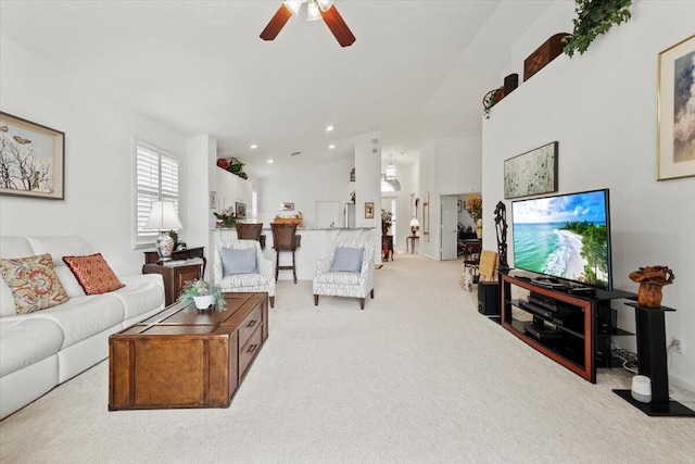 living room with ceiling fan, light carpet, and vaulted ceiling