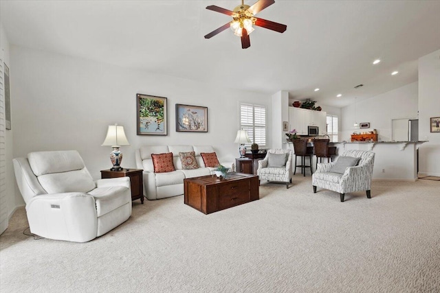 living room featuring light carpet, ceiling fan, and vaulted ceiling