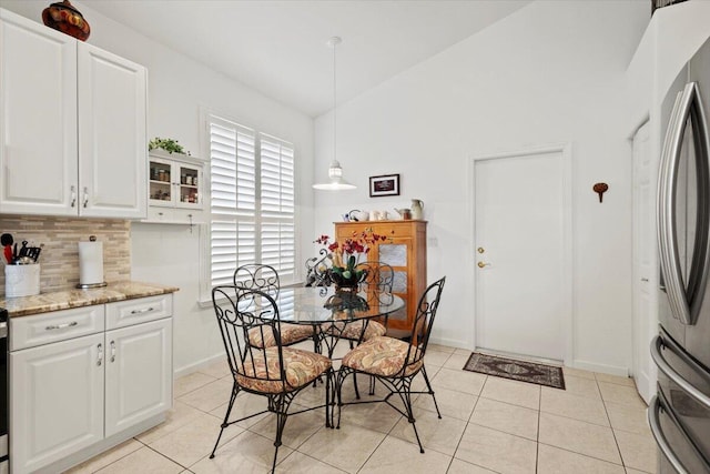 dining room featuring light tile patterned floors and vaulted ceiling