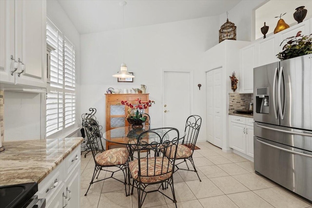 tiled dining room with plenty of natural light and lofted ceiling